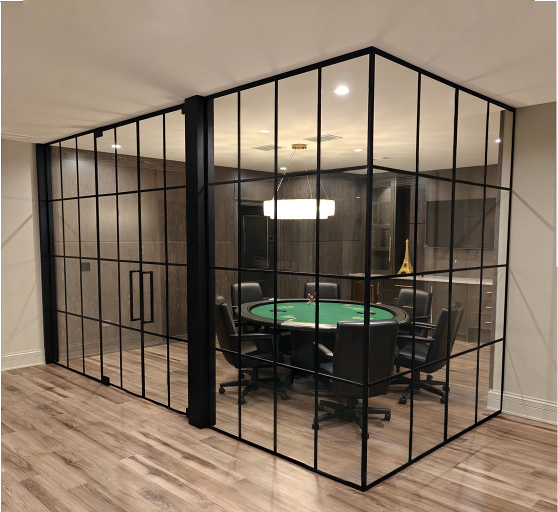 Black grid glass walls and double doors around a game room with a round poker table.